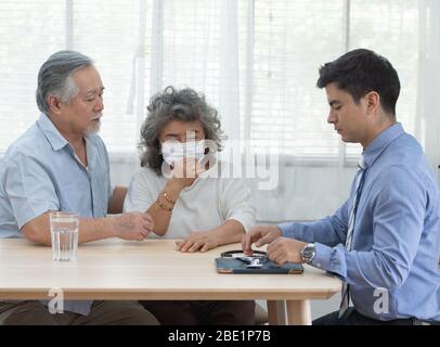 Un ancien couple asiatique âgé de haut niveau rencontre un médecin caucasien professionnel spécialiste visite chez un consultant à domicile deux patients de retraite après un contrôle Banque D'Images