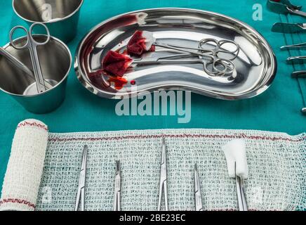 Chirurgie ciseaux avec torundas imbibé de sang sur un plateau métal dans une salle d'opération, la composition horizontale, conceptual image Banque D'Images