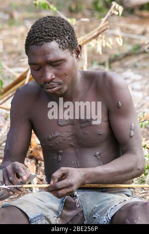 Les hommes d'Hadza préparent des flèches avant une expédition de chasse photographiée au lac Eyasi, en Tanzanie Banque D'Images