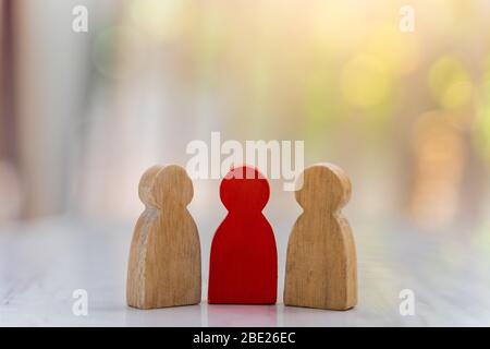 Figure dans le concept de gestion des ressources humaines. Le groupe de marionnettes en bois une figure en bois rouge comme une dominante dans un groupe avec un fond flou bokeh Banque D'Images