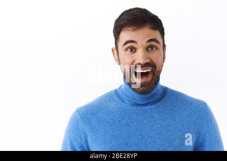 Portrait étroit d'un homme caucasien souriant et enthousiaste avec barbe, à la mode rêveuse et émerveillé par l'appareil photo, contemplant quelque chose de magnifique et Banque D'Images