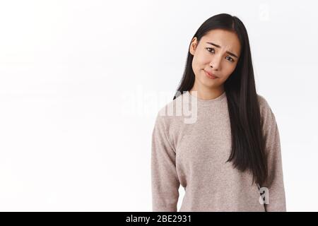 Sceptique, douteuse et mécontente, jeune fille est-asiatique smirk et tête inclinable, frognant semble pitié et bouleversé, pas comme les résultats, se sentant déçu Banque D'Images