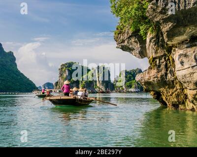 Les touristes apprécient une excursion en bateau avec des guides locaux à travers les majestueuses montagnes de calcaire de la baie de Halong, au Vietnam Banque D'Images