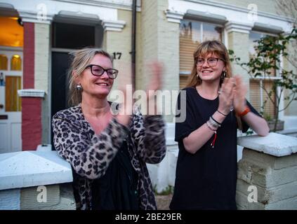 Les gens sortent de leur maison tous les jeudis à 20:00 pour la semaine "Clap pour les soignants". Ils montrent leur soutien aux travailleurs et aux soignants du NHS. Banque D'Images