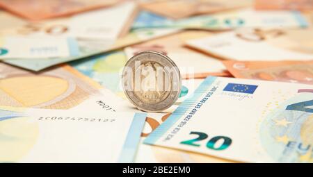 La monnaie en euros roule sur un fond de billets. Banque D'Images