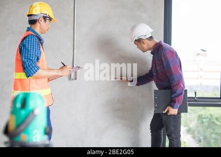 Inspection et marquage par l'équipe d'inspecteur de la construction par télémètre laser, mesure de la zone de la salle avec un télémètre laser. Banque D'Images