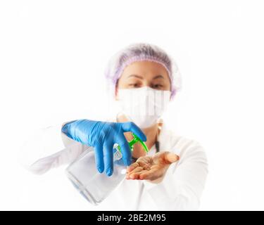 Infirmière femme dans le masque de protection médicale et gants montrant aseptisant ou savon antibactérien. Prévention et arrêt de l'infection concept. Banque D'Images