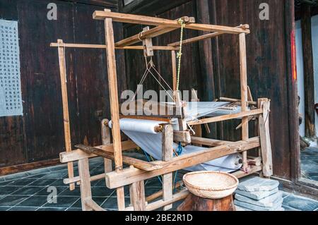 Un métier à tisser chinois traditionnel en bois est exposé dans un bâtiment de Luotiancun, un ancien village de la province du Jiangxi, en Chine. Banque D'Images