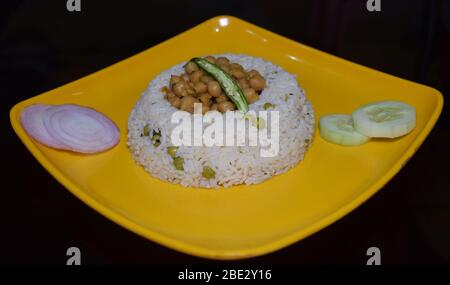 Délicieux plats indiens traditionnels Punjabi authentique Chaval Chole (riz avec plat de pois chiches) avec oignons en tranches, concombres, citron et piments verts Banque D'Images