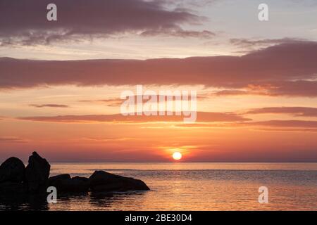 Coucher de soleil spectaculaire en hiver sur la mer et rochers exposés à Portwrinkle, Cornwall. Banque D'Images