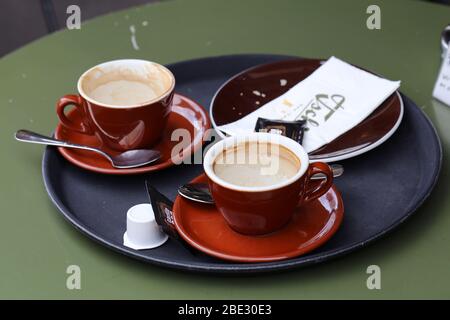 Table de cafétéria avec des tasses à café sales et des poubelles colorées. Les gens ont eu une pause café dans la cafétéria urbaine et ont laissé un gâchis derrière eux. Photo colorée. Banque D'Images