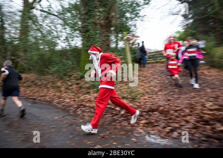 Coureurs, dont un vêtu comme Père Noël, dans une course de boxe Day. Banque D'Images