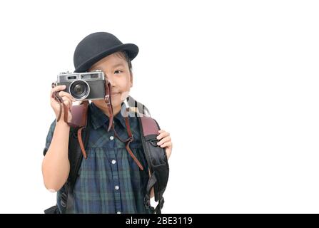 Jolie petite fille asiatique prend des photos avec un appareil photo vintage isolé sur fond blanc, concept de voyage et espace de copie Banque D'Images