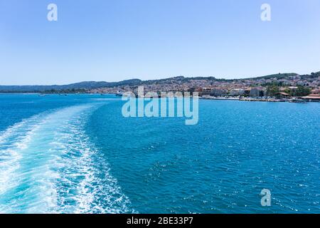 Vue sur la ville d'Argostoli à Céphalonie, Grèce, du ferry à voile à Lixouri. Sentier aquatique qui moussant derrière le ferry Banque D'Images