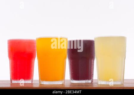 Jus de fruits frais colorés sur une table en bois Banque D'Images