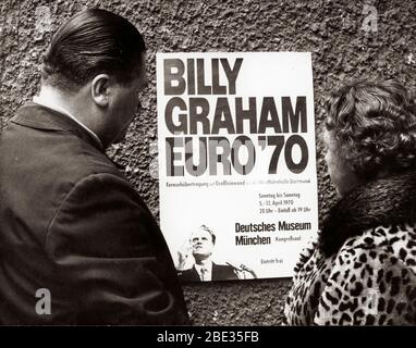 2 avril 1970 - Londres, Angleterre, Royaume-Uni - BILLY GRAHAM, né William Franklin Graham, Jr. Le 7 novembre 1918, est un révérend chrétien évangélique. Il a obtenu le statut de célébrité en diffusant ses sermons à la radio et à la télévision. PHOTO: Les citoyens lisent l'affiche pour la tournée européenne de Billy Graham. Banque D'Images