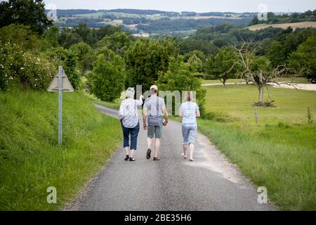 Une femme pointe vers l'avant alors que trois personnes descendent sur une voie de pays dans le sud-ouest de la France. Banque D'Images