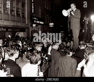 18 juin 1966 - Londres, Angleterre, Royaume-Uni - le révérend BILLY GRAHAM s'adresse à la foule du toit d'une voiture à Soho pour tenter de conduire l'armée morale dans ce qui était autrefois appelé le trou d'équipe de la désintégration pécheresse. Son discours n'a duré que quelques minutes, puis il a grimpé et est renparti. Banque D'Images