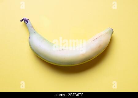 une fantastique image couleur pastel d'une banane sur fond jaune, plat, vue sur le dessus Banque D'Images