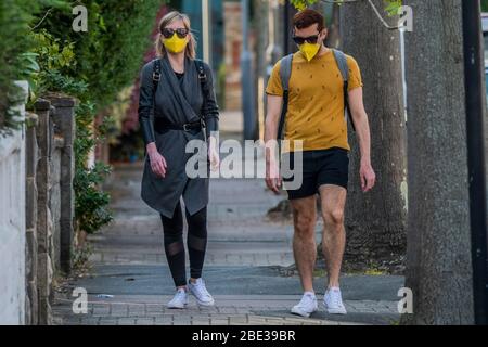 Londres, Royaume-Uni. 11 avril 2020. Un couple de masques assortis se dirige vers les mini Sainsburys de la station-service - le 'verrouillage' continue pour l'épidémie de Coronavirus (Covid 19) à Londres. Crédit: Guy Bell/Alay Live News Banque D'Images