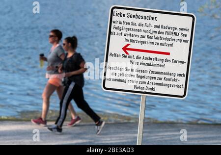 Dortmund, Allemagne. 11 avril 2020. Un panneau indique aux visiteurs du lac Phoenix d'utiliser la voie circulaire dans le sens horaire seulement pour endiguer la propagation du coronavirus. Le lac artificiel sur le site d'une ancienne aciérie est l'une des destinations récréatives les plus fréquentées de la ville. Crédit: Bernd Thissen/dpa/Alay Live News Banque D'Images