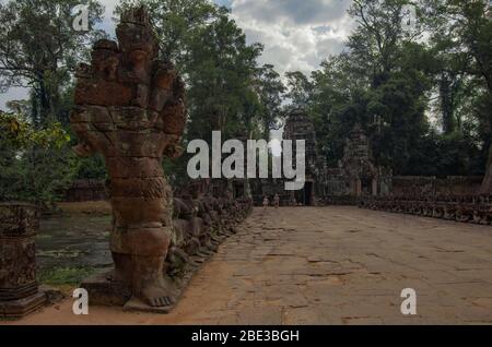 Entrée au temple de Preah Khan et pont au-dessus des statues décorées de canaux d'anciennes têtes de guerriers khmers portent un gigantesque serpent. Temple Angkor Wat Banque D'Images