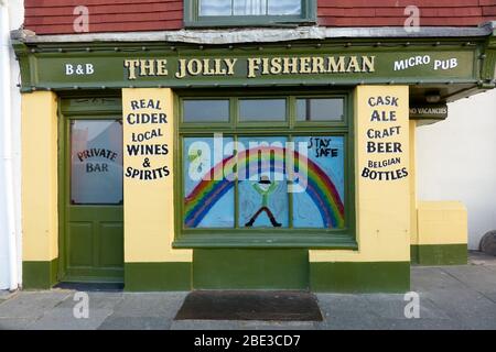 Le Jolly Fisherman pub à Hastings, fermé pendant le verrouillage du coronavirus, affiche un arc-en-ciel peint en solidarité, avec un message pour rester en sécurité Banque D'Images