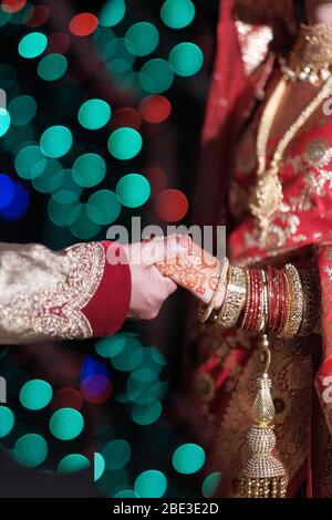 Gros plan sur la mariée indienne et la robe tenant main Banque D'Images