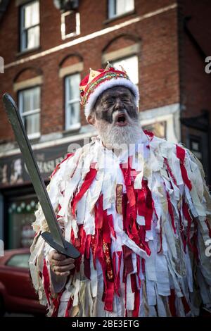 Les mommers vêtues de costumes traditionnels se remplissent au centre de Haslemere High Street à l'heure de Noël. Banque D'Images