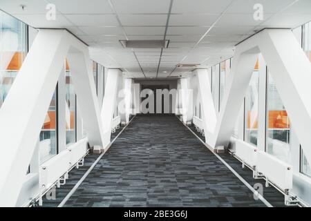 Passage moderne long et lumineux entre deux tours d'un bureau ou un gratte-ciel d'hôpital avec lignes en zigzag des poutres porteuses Banque D'Images