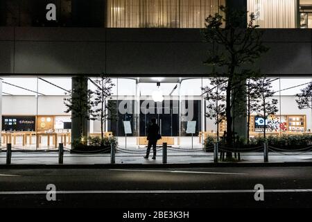 Un homme se tient devant un magasin de pommes fermé. Le gouvernement japonais a déclaré l'état d'urgence pour couvrir les préfectures de Tokyo, Osaka, Saitama, Kanagawa, Chiba, Hyogo et Fukuoka à partir du 7 avril et continuera jusqu'au 6 mai. Le gouverneur de Tokyo Yuriko Koike a demandé que les restaurants et les bars soient fermés à 20:00, à mesure que le virus COVID-2019 se propage. Banque D'Images