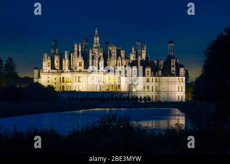 France, Loir-et-Cher (41), Chambord (patrimoine mondial de l'UNESCO), château royal de la Renaissance illuminé de nuit, vue du canal le Cosso Banque D'Images