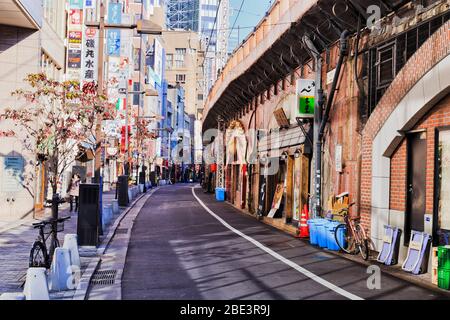 Tokyo, Japon - 1 Jan 2020: Petite allée arrière le long du chemin de fer japonais et bâtiments de grande hauteur autour de la centrale staion une journée ensoleillée. Banque D'Images