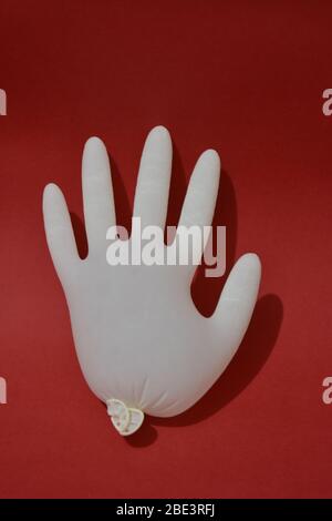 Gants médicaux blanc isolé sur fond rouge. Protection Banque D'Images