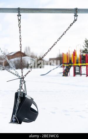 Balançoire liée installée dans un terrain de jeux fermé pendant la pandémie du coronavirus en hiver, Yellowknife, Territoires du Nord-Ouest, Canada, avril 2020. Banque D'Images