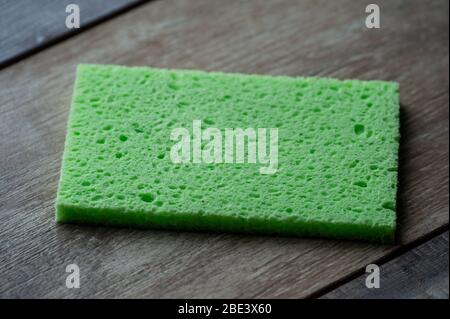 Objets de cuisine en éponge de cellulose sur le fond de la texture du bois. Serviette en cellulose sur la table. Banque D'Images