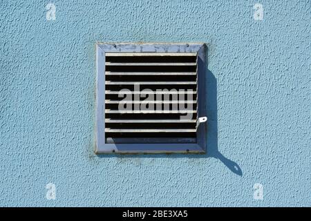 grille de ventilation en métal carrée dans un mur bleu, vue rapprochée, pour un air frais et un refroidissement Banque D'Images