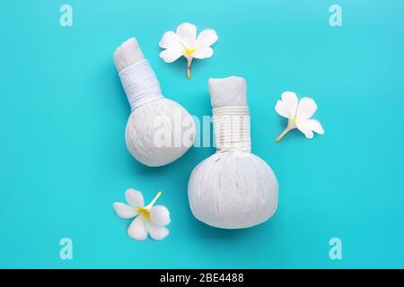 Plumeria ou frangipani fleur avec des boules de compression de plantes pour le massage thaïlandais et le soin spa sur fond bleu. Espace de copie Banque D'Images