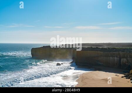 Une falaise calcaire fine fait face à la route côtière de Great Ocean Road, avec une mer qui s'est enfilée des vagues en contrebas à Victoria, en Australie. Banque D'Images