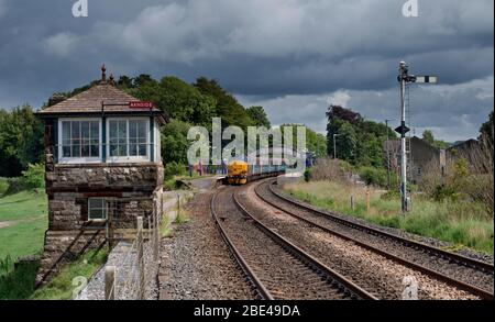 Locomotive DRS classe 37 à la gare d'Arnside avec la boîte de signalisation ferroviaire Furness et le signal de domicile semaphore tout en travaillant dans un train du nord Banque D'Images