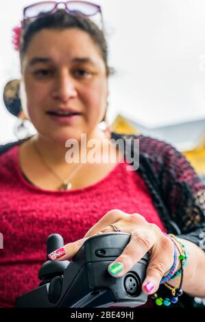 Femme maorie avec paralysie cérébrale en fauteuil roulant, ongles montrant l'art des ongles; Wellington, Nouvelle-Zélande Banque D'Images