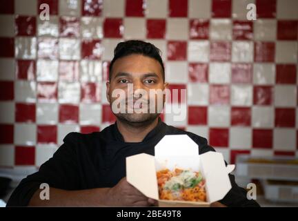 Potsdam, Allemagne. 7 avril 2020. Le chef Shakeel a préparé une partie de la penne avec de la salsiccia dans le restaurant 'Genusswerkstatt' au Filmmuseum et a mis la nourriture dans une boîte pour le 'hors-de-maison'. Les clients ne sont pas autorisés à s'asseoir et à manger dans les restaurants pendant les restrictions imposées par le Corona danger. (Pour les boissons fraîches et le délicieux risotto: Pour aller au signe de Corona) crédit: Soeren Stache/dpa-Zentralbild/ZB/dpa/Alay Live News Banque D'Images