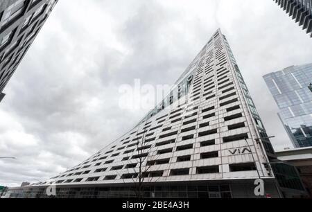 Un bâtiment architectural frappant à la 57ème rue près des Piers semble se plier vers l'intérieur. Les nuages sombres d'une journée surmoulée donnent un sentiment inquiétant Banque D'Images