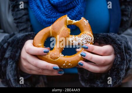 Femme mangeant un bretzel; New York City, New York, États-Unis d'Amérique Banque D'Images