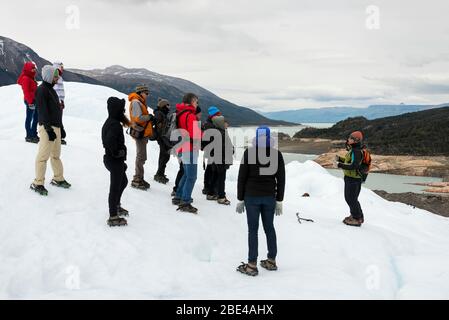 Les touristes écoutent un guide alors qu'ils se trouvent sur un glacier dans le parc national de Los Glaciares, province de Santa Cruz, Argentine Banque D'Images