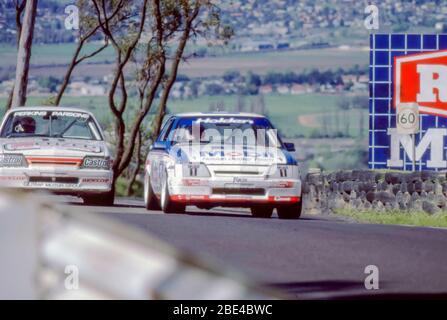 Bathurst, Australie, le 5 octobre 1986 : Enzed Team Perkins, Holden VK Commodore SS Group A, courses avec l'une des deux voitures Mobil Holden Dealer Team du même modèle à la course James Hardie (Bathurst) 1000 de 1986. Les voitures sont représentées sur une partie de la section en pente raide du circuit de rue de 6,213km Banque D'Images