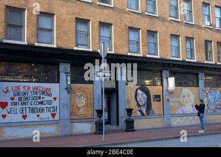 Vancouver, Canada, 10 avril 2020. Un homme photographie des peintures murales de rue peintes sur la fenêtre de bord d'un magasin à Gastown pendant la pandémie COVD-19. Banque D'Images