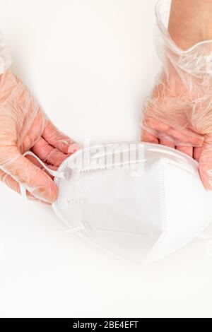 Les mains des femmes portent des gants en vinyle portant des masques de protection KN-95. Gros plan, isolé sur fond blanc. Prévention de la propagation de viru Banque D'Images