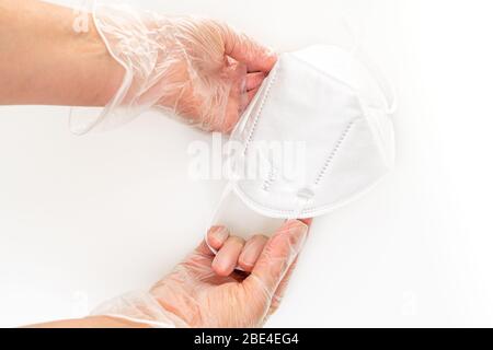 Les mains des femmes portent des gants en vinyle portant des masques de protection KN-95. Gros plan, isolé sur fond blanc. Prévention de la propagation de viru Banque D'Images