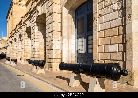 De vieux canons alignés devant la façade du musée marin de Malte Banque D'Images